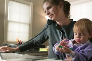 Woman talking through the phone while holding her baby