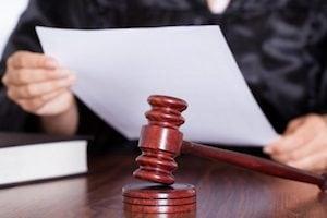 Judge reading a sheet of paper and a chisel